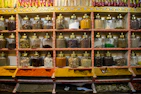 Brightly lit kitchen scene with jars of specialty spices like chat masala and kitchen king on a shelf.