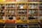 A vibrant display of various spices in colorful containers arranged on a wooden shelf.