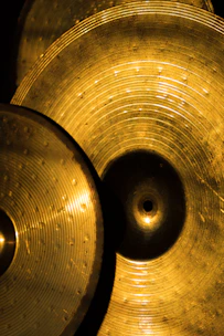 Close-up of bronze gongs shimmering under soft light, showcasing intricate Balinese craftsmanship.