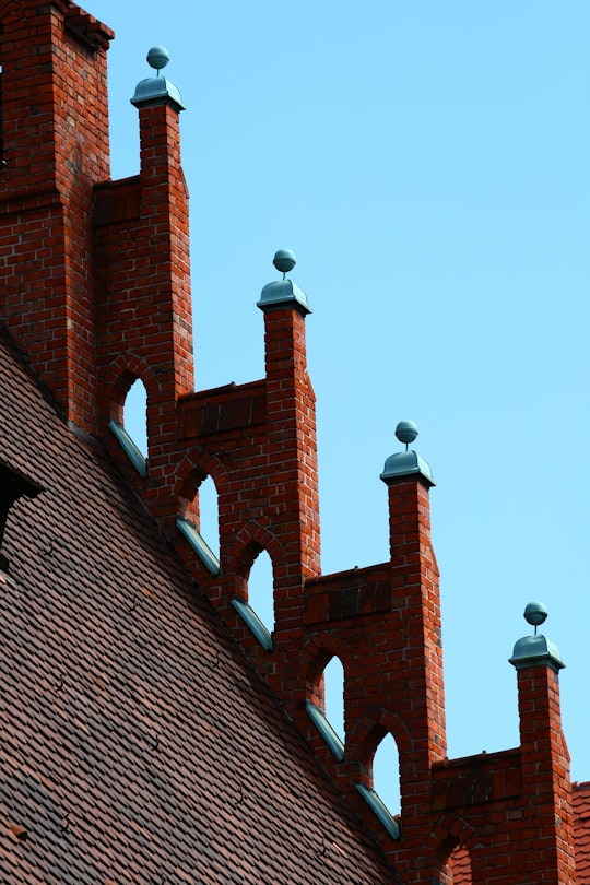 man in black jacket and black pants standing on brown brick wall during daytime in Nuremberg Germany