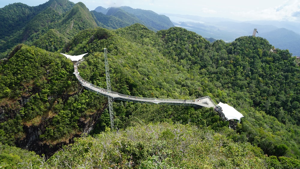 ponte branca sobre montanhas verdes durante o dia