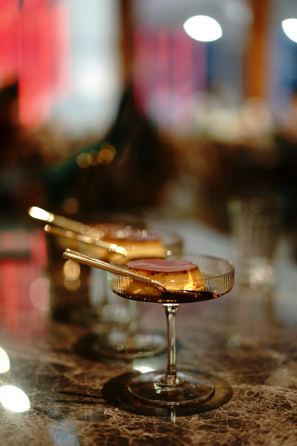 bokeh photography of brown liquid in clear drinking glass