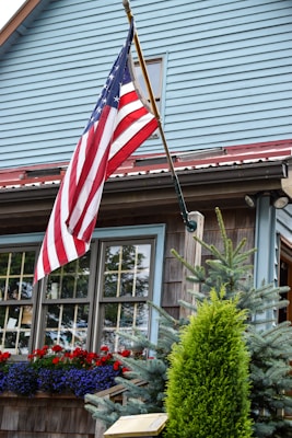 us a flag near white wooden house