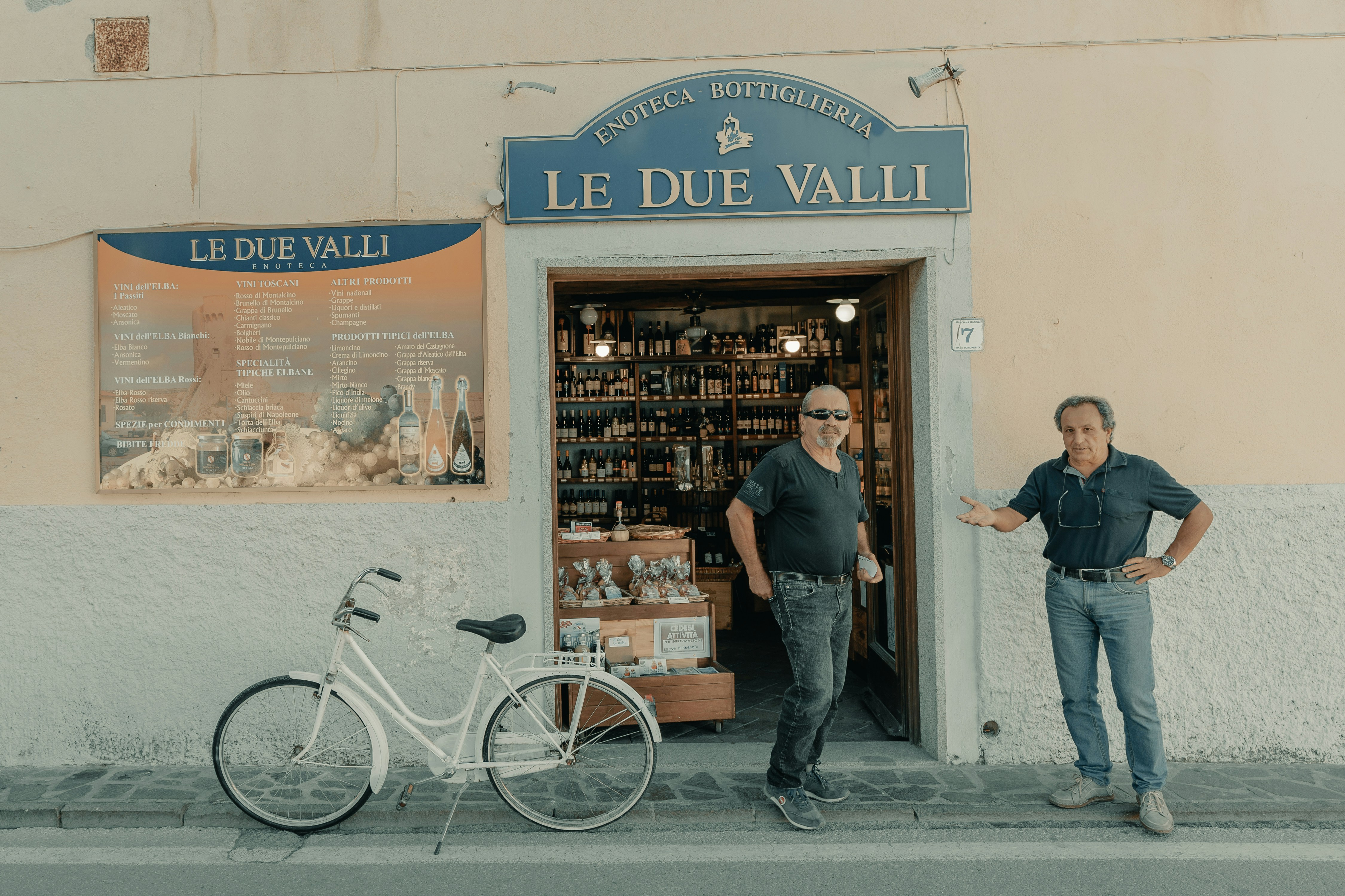 man in black jacket standing beside bicycle
