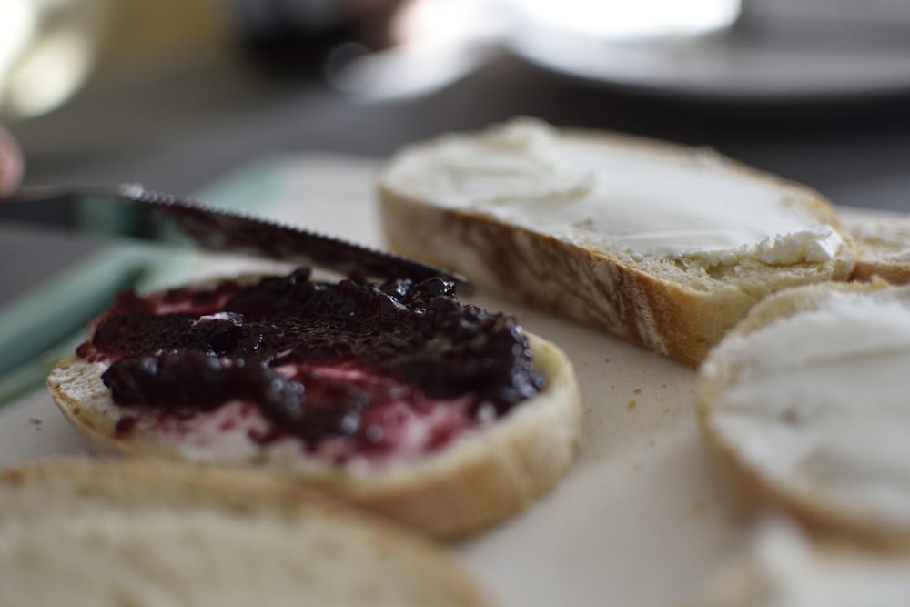 sliced bread with black and red sauce on white ceramic plate