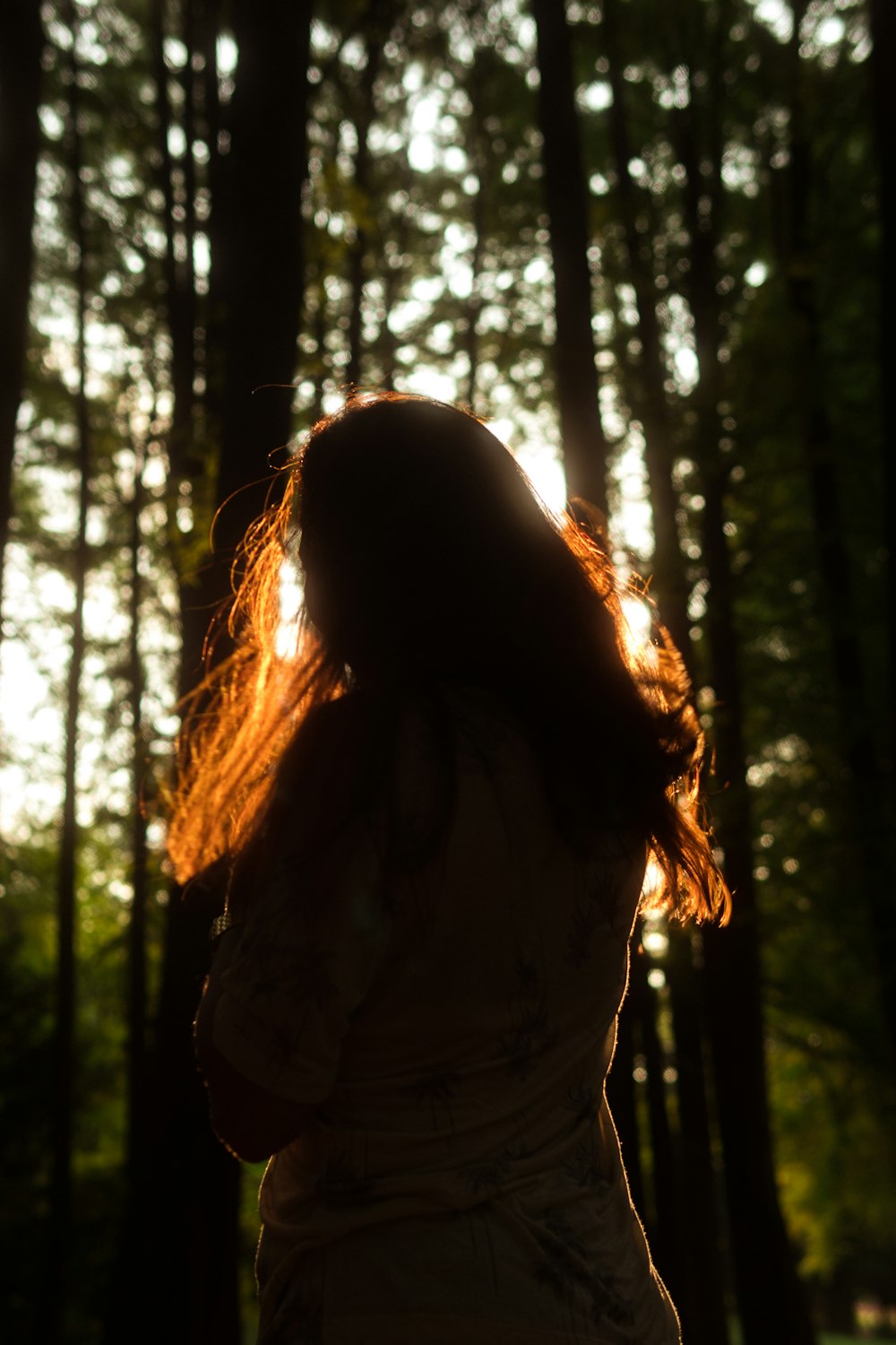 woman in white shirt standing in forest during daytime