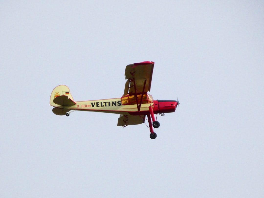 red and yellow plane flying in the sky