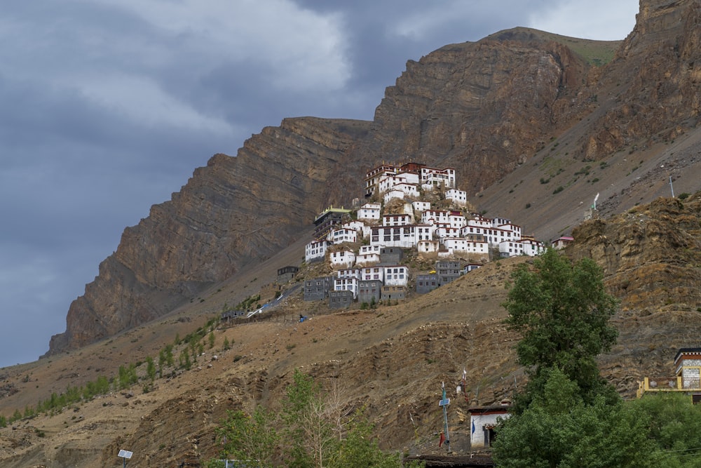 white and brown concrete building near mountain under white clouds during daytime