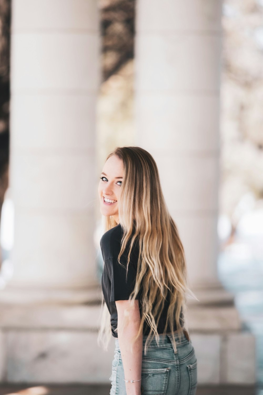 woman in black blazer standing on sidewalk during daytime