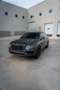 Modern SUV with a sleek matte black finish parked outdoors on a sunny day.