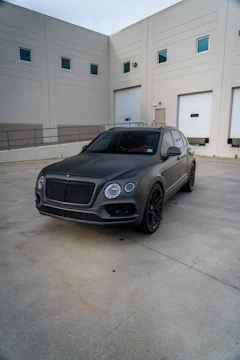 Modern SUV with a sleek matte black finish parked outdoors on a sunny day.