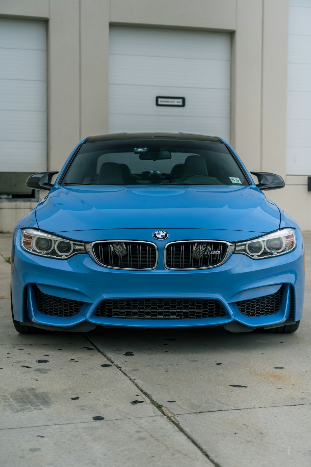 blue bmw m 3 parked in front of white building