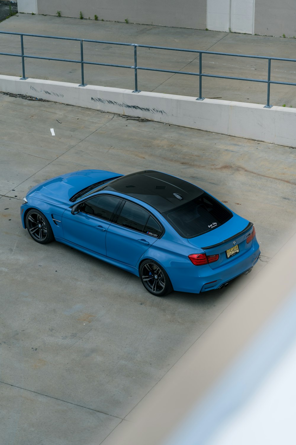 blue sedan parked on gray concrete floor