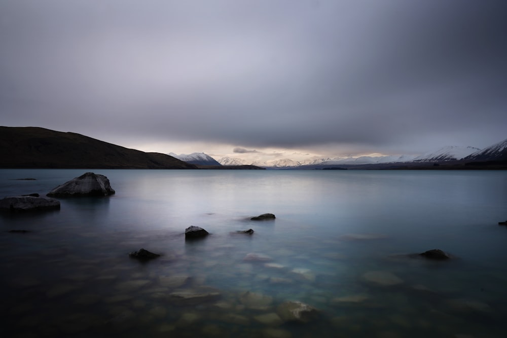 body of water near mountain during daytime