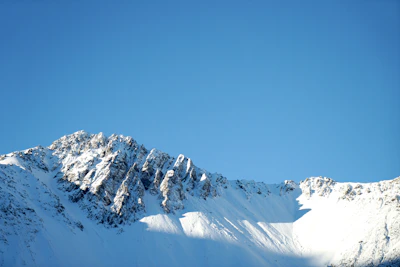 Snow-capped Himalayan peaks stretching against a clear blue sky at dawn.