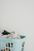 A laundry basket filled with colorful clothes ready for washing.
