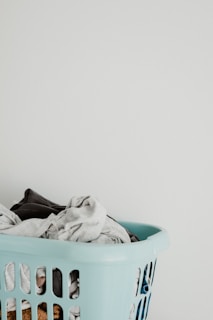 A hanging laundry basket filled with fresh clothes in a cozy laundry room.