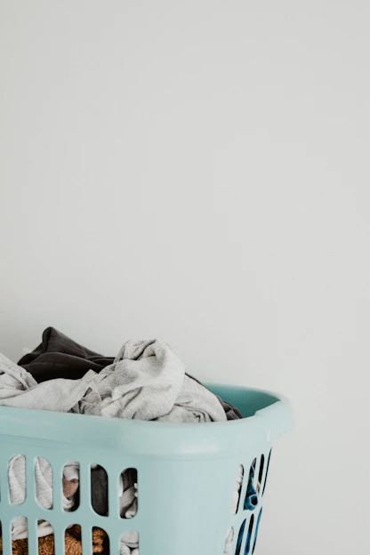 A cozy laundry nook with neatly stacked erdvėja baskets filled with fresh clothes.