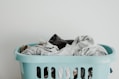 white textile on blue plastic laundry basket