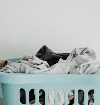 white textile on blue plastic laundry basket