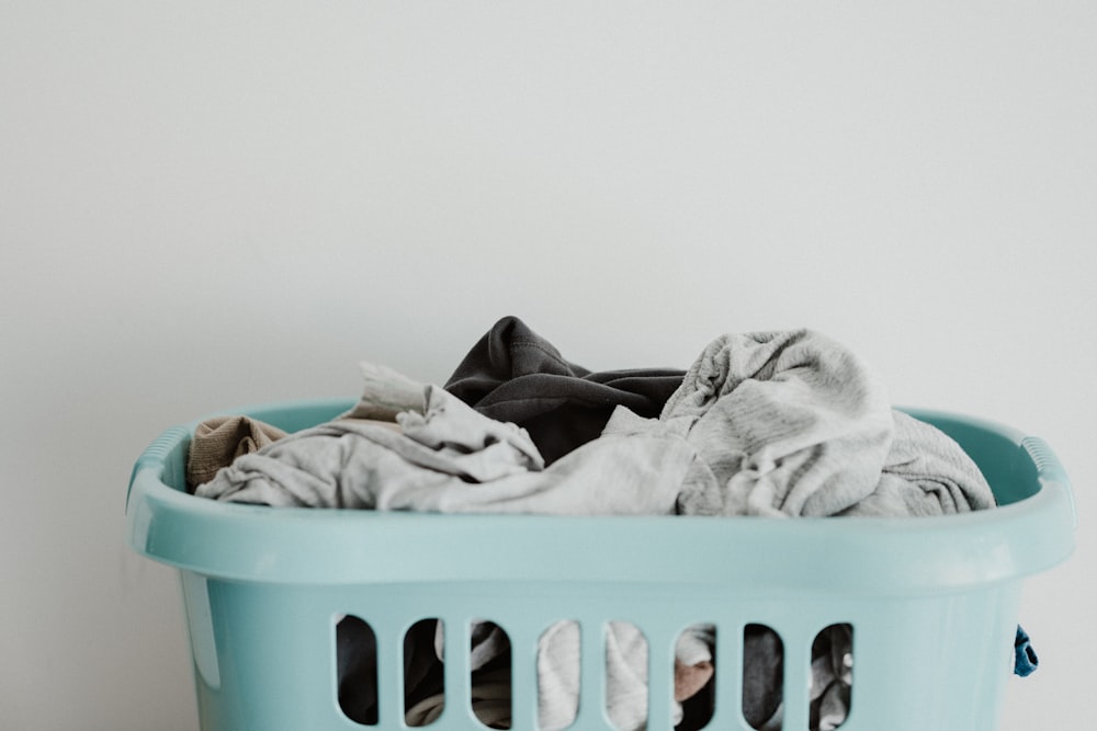 white textile on blue plastic laundry basket
