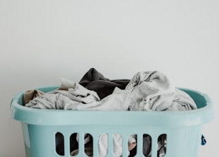 white textile on blue plastic laundry basket