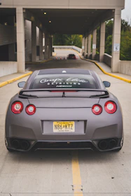 A sleek car with new license plates being handed over to a happy owner.