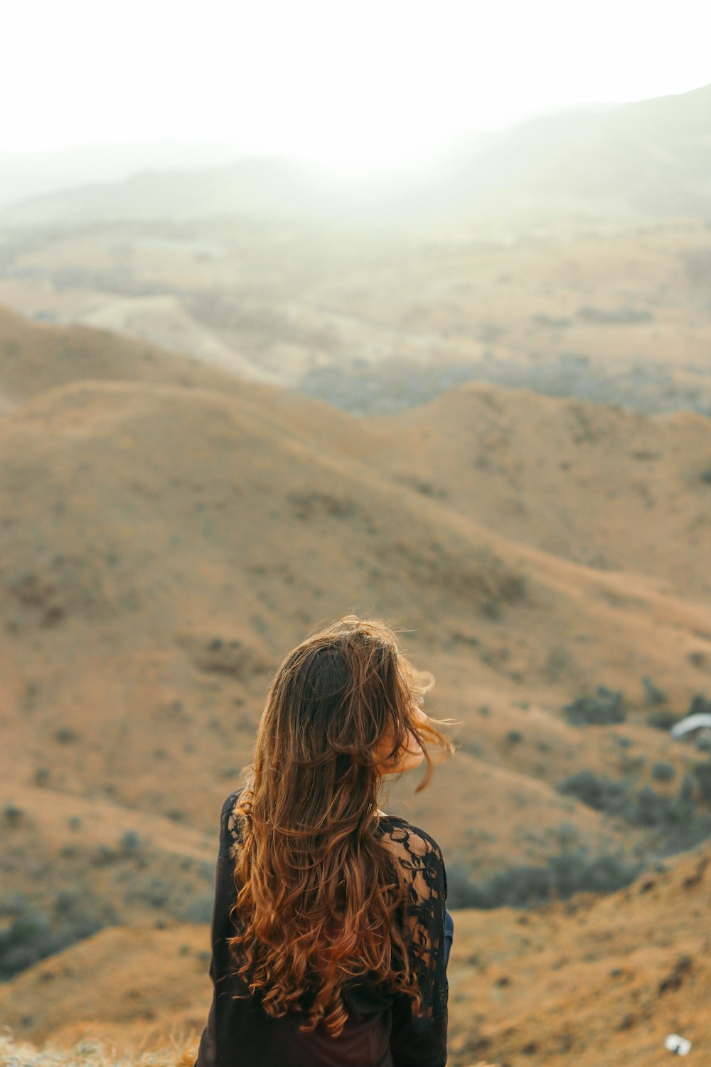 woman in black shirt looking at the mountains during daytime