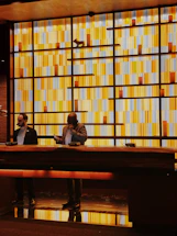 Cozy reception desk with warm yellow lighting and eucalyptus decor.