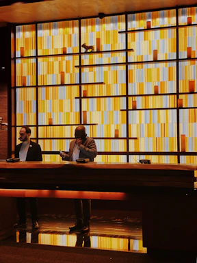 Cozy reception desk with warm yellow lighting and eucalyptus decor.