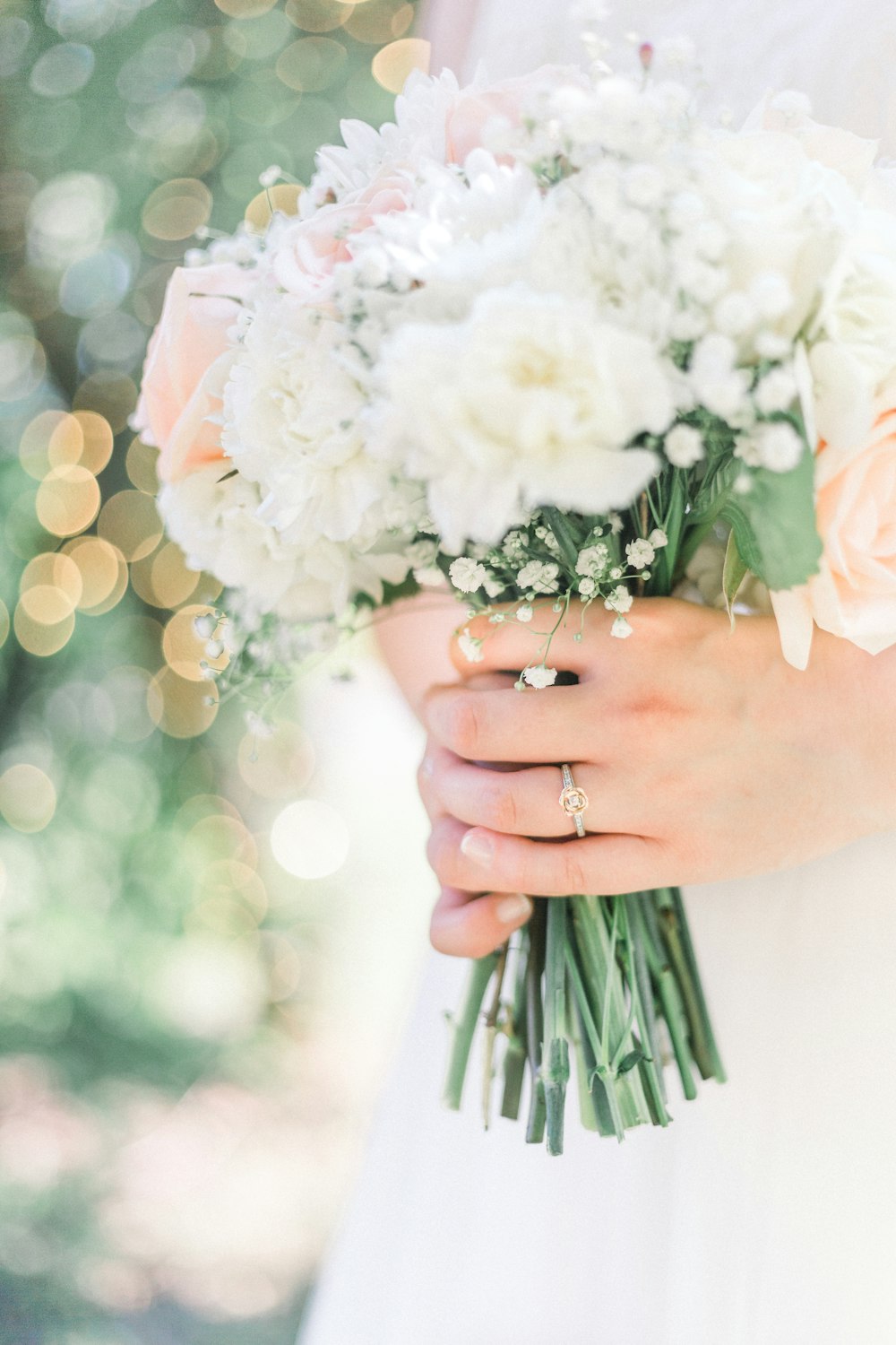 person holding white flower bouquet