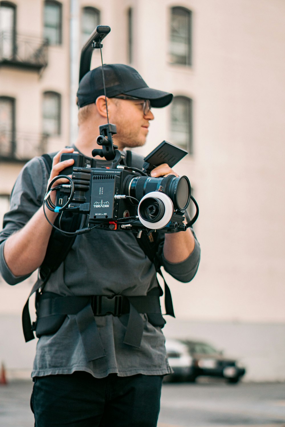 Mann in schwarz-grauer Tarnuniform mit schwarzer DSLR-Kamera