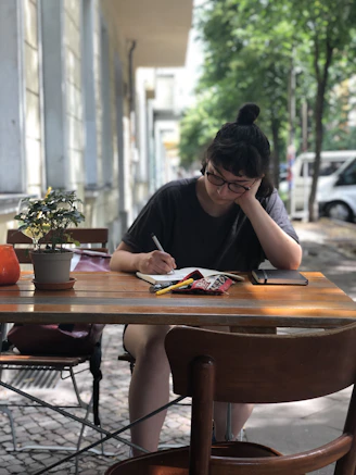 woman in black shirt sitting at the table
