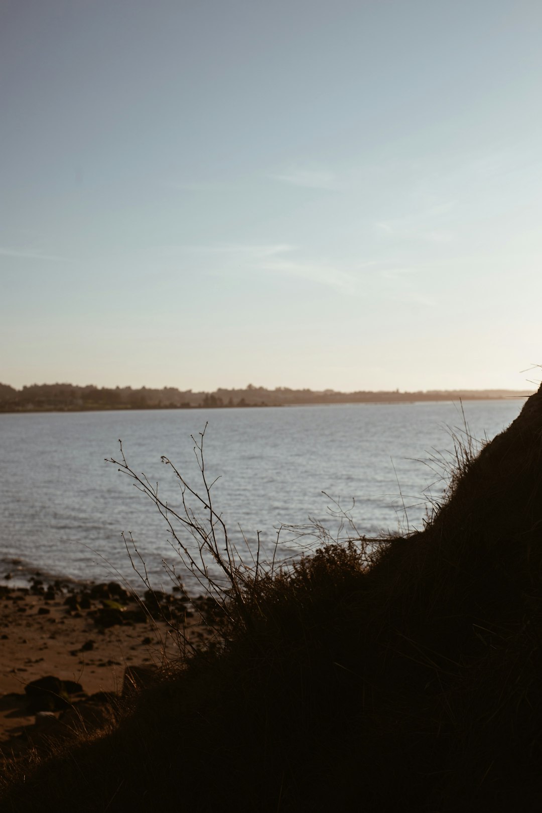 body of water near mountain during daytime