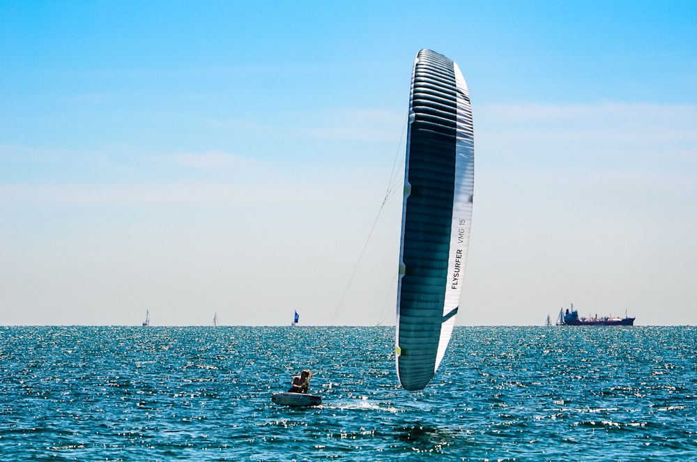 people riding on white and blue sail boat on sea during daytime