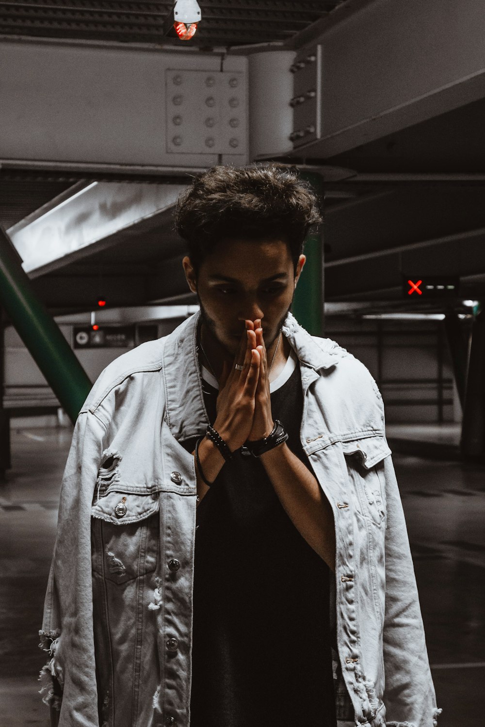 man in black tank top wearing white jacket smoking cigarette