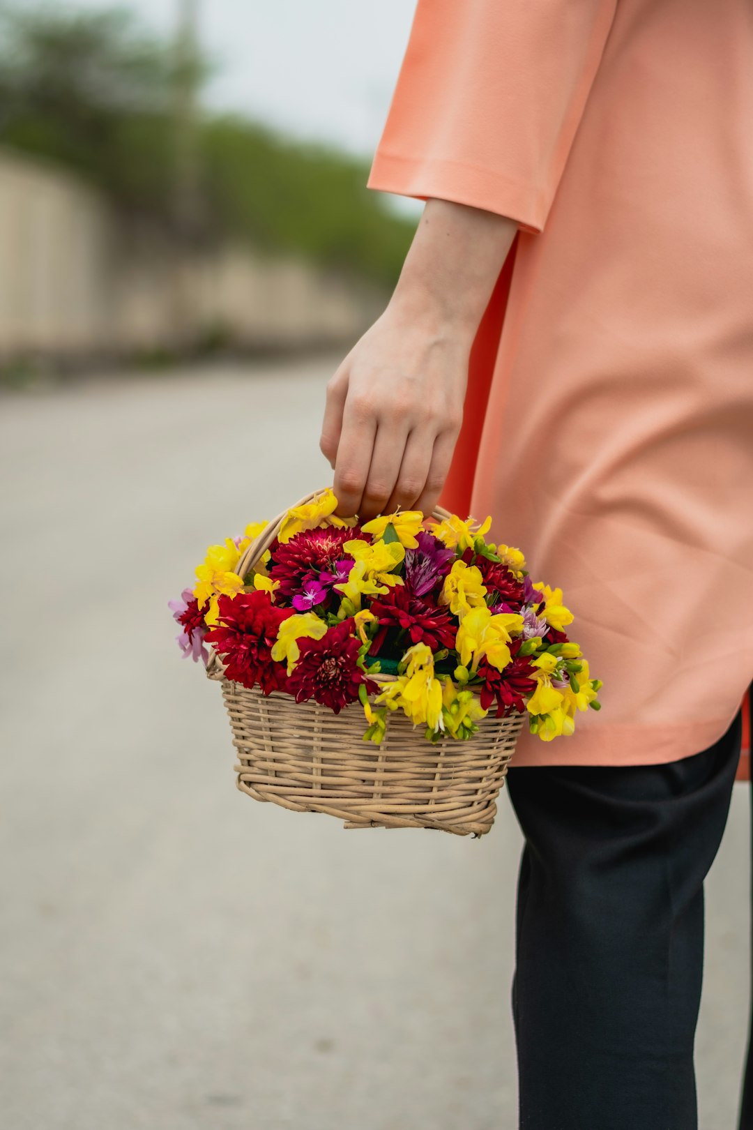 person holding yellow and purple flower bouquet