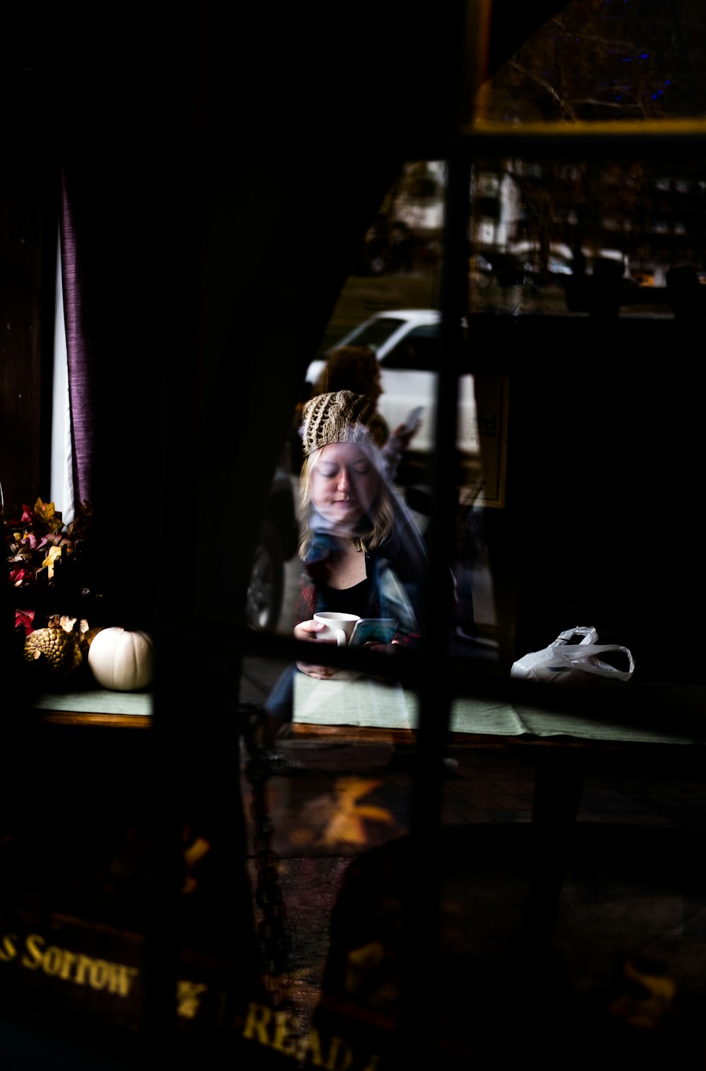 woman in blue denim jacket sitting on brown wooden chair