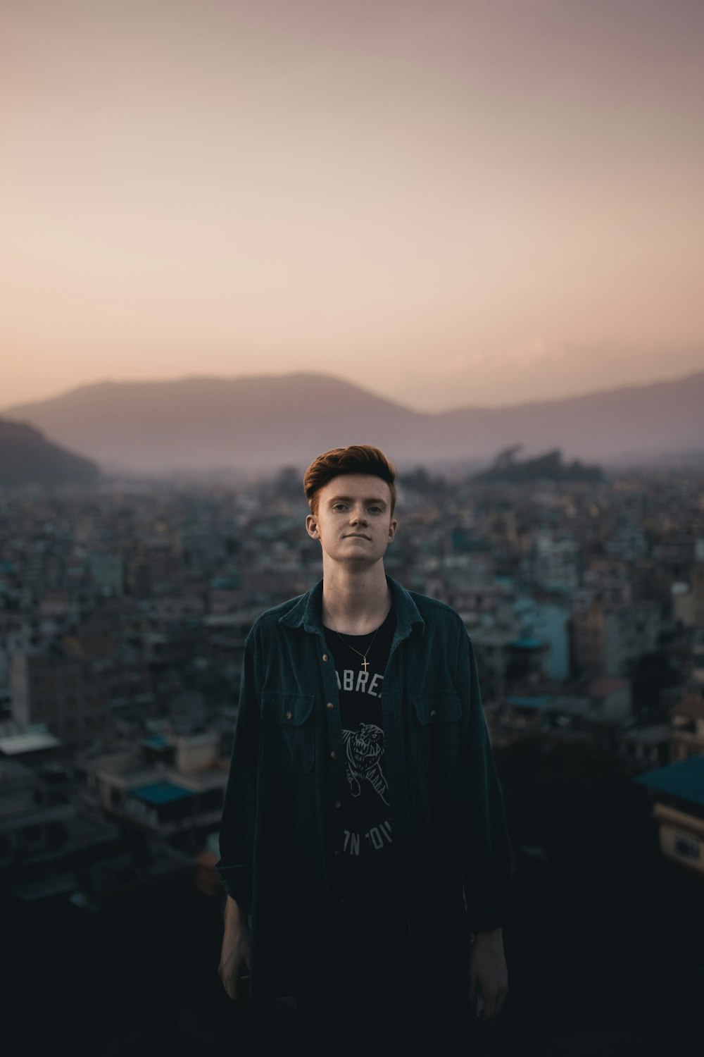 man in black jacket standing on top of building during daytime