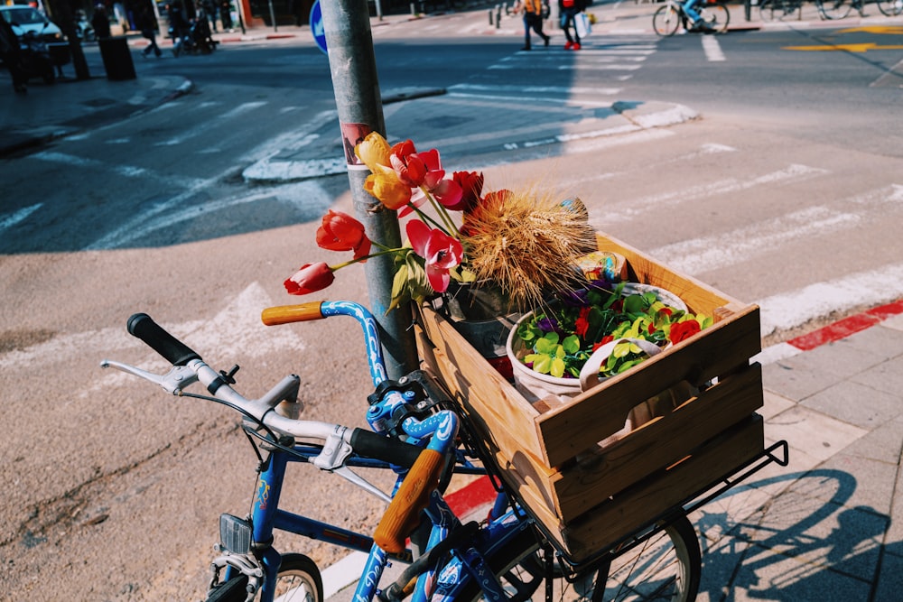 blue bicycle with red and white flowers on top