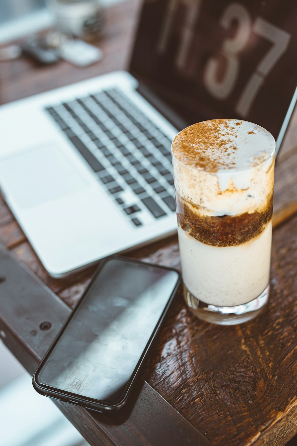 clear drinking glass with white liquid on brown wooden table