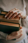 person holding a stack of books