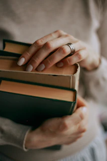 person holding a stack of books