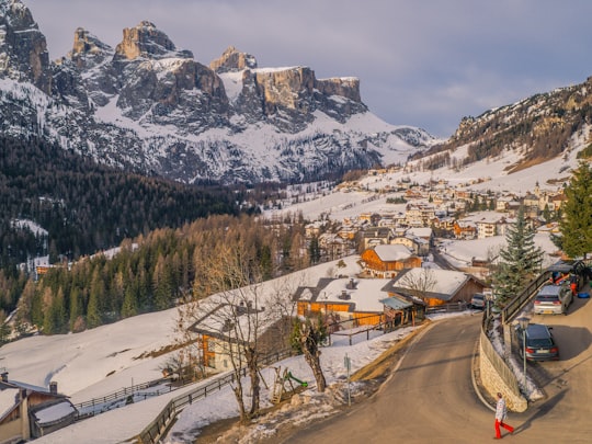 gray concrete road near snow covered mountain during daytime in Colfosco Italy