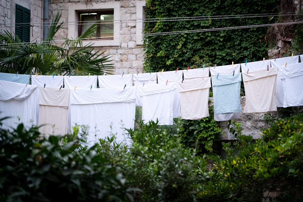 white and blue textiles hanging on wire fence