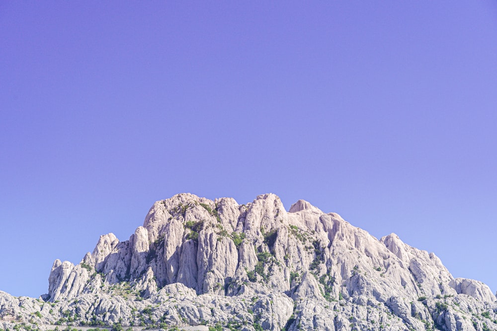 昼間の青空の下の灰色の岩山
