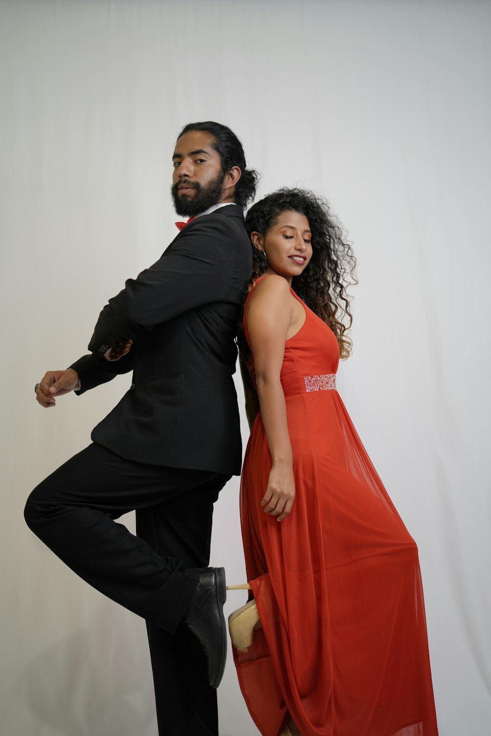 man in black suit jacket and woman in red dress