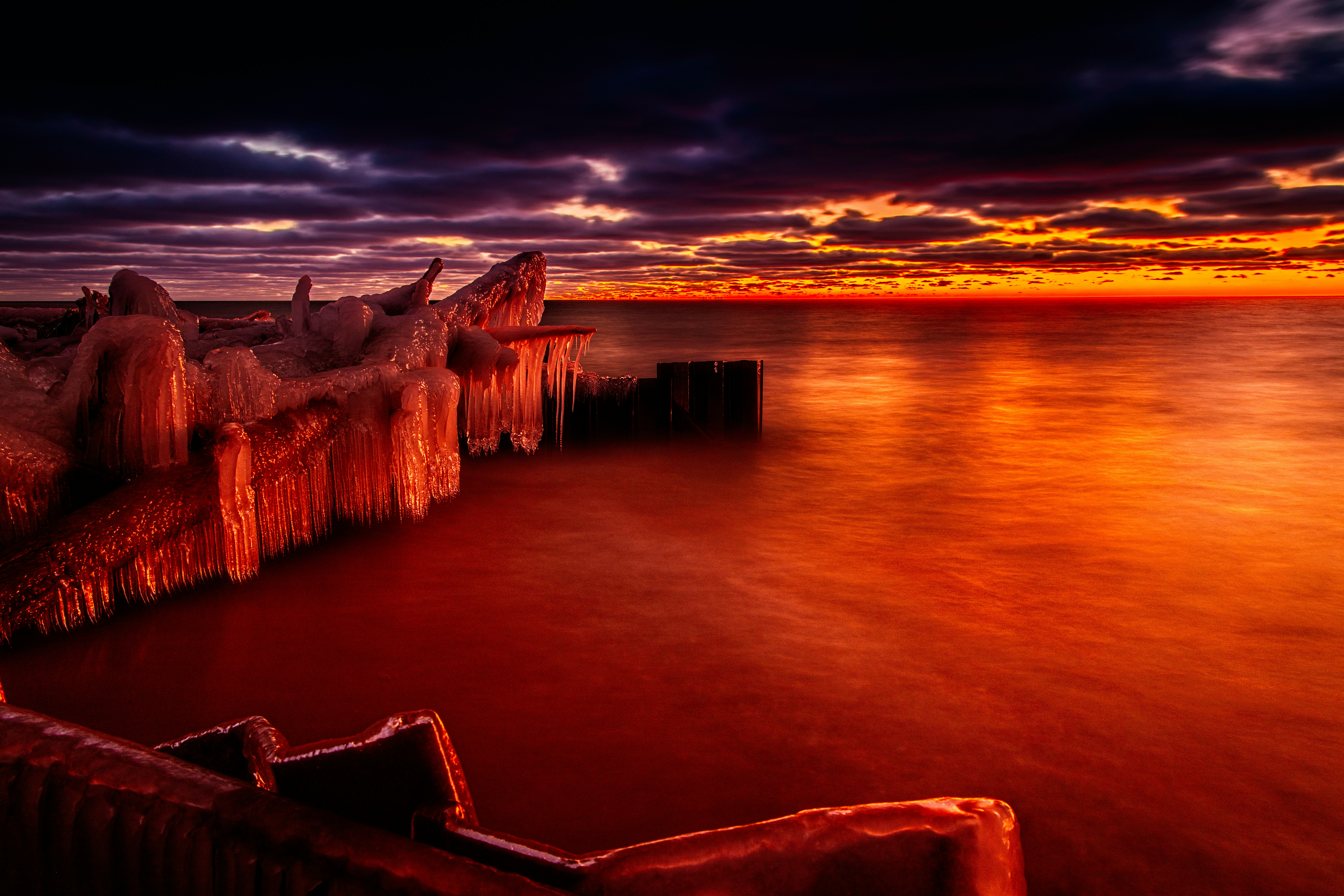 brown wooden dock on sea during sunset