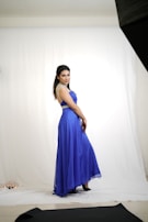 Evening wear ensemble with deep blue hues illuminated by soft lighting.