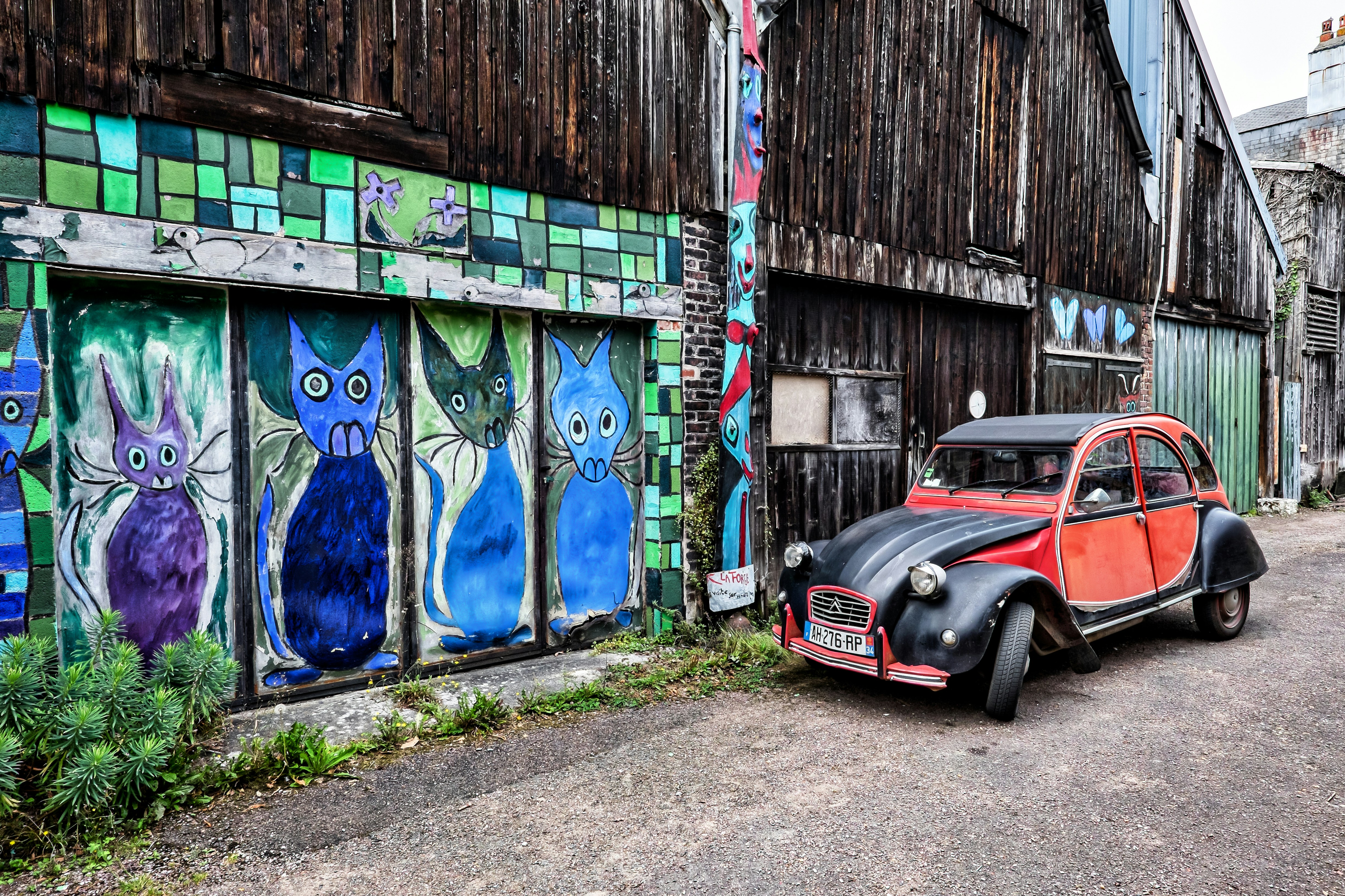 coche negro aparcado junto a la pared pintada de azul y blanco